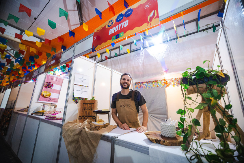 Foto do Chefe Thiago Brandão em sua barraca com decorações de festa junina.